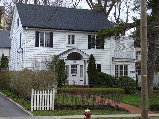 white home with small yard and white fence